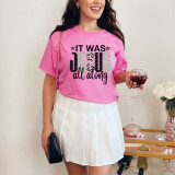 It Was Jesus All Along DTF Heat Transfer, pink t-shirt with humorous and religious text, worn by a smiling woman holding a glass of wine.