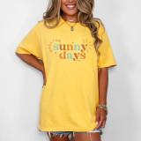 Made For Sunny Days DTF Heat Transfer, colorful printed design on a yellow t-shirt worn by a smiling woman.
