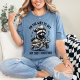 On The Way To Get My Shit Together Raccoon DTF Heat Transfer, humorous graphic T-shirt featuring a raccoon wearing a cowboy hat riding a turtle, in black and white with bold text, suitable for casual wear.