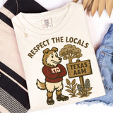 Respect Your Locals - PICK YOUR TEAM DTF Heat Transfer T-shirt with a cartoon dog character wearing a Texas A&M sweater, standing next to a tree and a wooden sign that reads 'TEXAS A&M'.