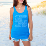 My Worship Is Loud Because My Wounds Were Deep WHITE DTF Heat Transfer, a woman wearing a bright blue tank top with the text 'My Worship Is Loud Because My Wounds Were Deep' printed on it, standing on a sandy beach with dunes and grasses in the background.