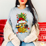 Christmas Pineapple DTF Heat Transfer, colorful pineapple design with sunglasses and holiday accessories on a woman's gray T-shirt