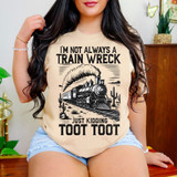 I'm Not Always a Train Wreck Just Kidding Toot Toot DTF Heat Transfer T-shirt, worn by woman sitting indoors, with a vintage train illustration and desert cacti graphic.