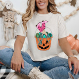 Cowgirl Boots Pumpkin Bucket DTF Heat Transfer, cartoon-style pumpkin bucket with jack-o'-lantern face filled with colorful jewelry and a pair of pink cowgirl boots with black stars.