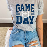 Game Day Various Colors/Puff Ink Screen Print, a gray T-shirt with the word 'GAME' and 'DAY' printed in distressed blue font along with a football graphic in the center.