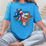 Pray For Texas Wooden Cross DTF Heat Transfer, colorful graphic design on a blue t-shirt featuring a wooden cross, Texas-themed bow, floral pattern, and the words "Pray for Texas Hill Country."