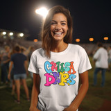 Colorful Jumping Mascot DTF Heat Transfer, vibrant multicolor cartoon mascot design on a white T-shirt worn by a smiling woman at an outdoor event.