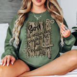 God Is Within Her Camo DTF Heat Transfer, a woman wearing a green sweatshirt with a camouflage background and a decorative cross design.