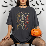 Dancing Patterned Skeletons DTF Heat Transfer, skull and skeleton graphic design with bats and stars on a woman's oversized gray T-shirt.