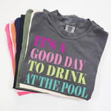 It's A Good Day To Drink At The Pool DTF Heat Transfer, folded grey T-shirt with colorful text design for pool or summer themed apparel.