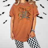 Patterned Fall Bow DTF Heat Transfer on a T-shirt featuring a large autumn-themed bow with the word 'FALL' in animal print designs.