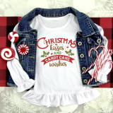 Christmas Kisses and Candy Cane Wishes sublimation transfer on a white shirt, with holiday-themed text and graphics, displayed with Christmas candies and a denim jacket.