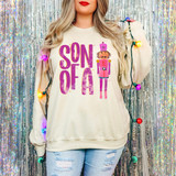 Preppy Son Of A Nutcracker DTF Heat Transfer, a graphic sweatshirt featuring a humorous nutcracker character with the text 'SON OF A'.