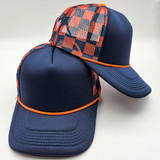Navy & Orange Checkered Foam Trucker Hat, sporting a checkered pattern on the mesh panel and a solid navy brim with orange trim.