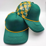 Green & Gold Checkered Foam Trucker Hat, a stylish cap with a vibrant checkered pattern on the back and a solid green front with a yellow trim.