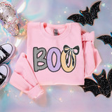 Boo Coquette Seersucker DTF Heat Transfer, pink sweatshirt with Halloween-themed design featuring the word 'BOO' in colorful striped and outlined letters with a bow accent, surrounded by Halloween decorations including bats and fairy lights.