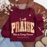 I Will Praise Him In Every Season Fall Patterns DTF Heat Transfer, a maroon sweatshirt with autumn-themed text and patterns, layered on a brown jacket with fall leaves around.