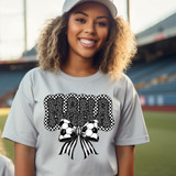 Soccer Nana Bow DTF Heat Transfer, colorful sports-themed design on a gray t-shirt worn by a smiling woman at a stadium.