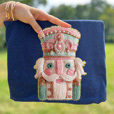 Faux French Knot Nutcracker DTF Heat Transfer, embroidered nutcracker design on blue fabric showcase.