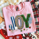 Faux Yarn Patterned Joy DTF Heat Transfer, pink sweatshirt with holiday-themed embroidery design of the word 'JOY' decorated with faux yarn patterns, snowflakes, holly berries, and gift box motifs.