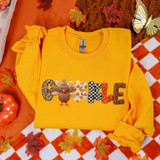 Faux Yarn Patterned Gobble DTF Heat Transfer, yellow sweatshirt with a pumpkin and leaf pattern, autumn-themed, for fall fashion.