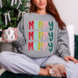Stacked Merry DTF Heat Transfer, colorful holiday-themed text design on a gray sweatshirt.