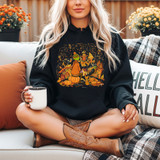 Thankful Green Guy DTF Heat Transfer, Halloween-themed design on a black hoodie featuring a festive scene with a pumpkin-headed character, houses, and pumpkins in fall colors.