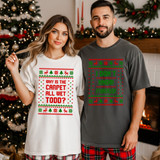 Why Is The Carpet Wet Todd? Sweater Pattern DTF Heat Transfer, a woman and a man wearing holiday-themed printed T-shirts with Christmas sweater patterns, standing indoors near a Christmas tree and fireplace.