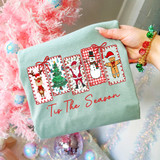 Tis The Season Christmas Favorites DTF Heat Transfer, festive holiday sweatshirt with Christmas-themed characters including a reindeer, Christmas tree, Santa Claus, snowman, and gingerbread man.