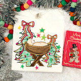 Baby Jesus In The Manger DTF Heat Transfer, colorful holiday-themed design featuring baby Jesus in a manger with decorated Christmas trees, stars, and bows.