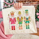 Colorful Nutcracker Trio DTF Heat Transfer, illustrated nutcracker soldiers in vibrant costumes with gold accents and glitter background, ideal for holiday craft projects.