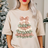 Faux Latch Hook Pastel Tree DTF Heat Transfer, a decorative mini Christmas tree made of pastel-colored yarn with bow topper on a woman's beige T-shirt.
