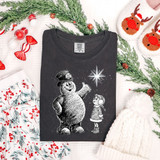 Magical Snowman DTF Heat Transfer, a black t-shirt with a snowman and girl design under a starry sky.