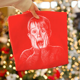 Kevin Half Tone DTF Heat Transfer, red fabric with white distressed print of a surprised boy on Christmas background.