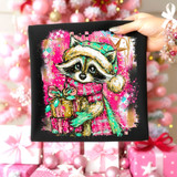 Preppy Winter Raccoon DTF Heat Transfer, colorful digital illustration of a raccoon wearing a holiday hat and scarf holding a gift, on black background for Christmas decorating.