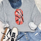 Basketball Number Sequin Patch, red sequined patch with black and white lines resembling a basketball number on a gray sweatshirt worn with distressed jeans and white sneakers.
