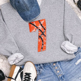 Basketball Number Sequin Patch, detailed orange sequin patch with black basketball line design on a grey sweatshirt.