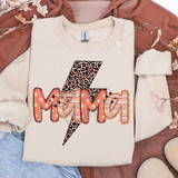 Patterned Names DTF Heat Transfer, a shirt with a 'Mom' design featuring a lightning bolt with leopard print and striped, floral, and outlined styles, laid on a brown jacket and surrounded by pink dried flowers.