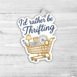 I'd Rather Be Thrifting Die Cut Sticker, sticker featuring a shopping cart filled with vintage dishware and a lamp, with the phrase 'I'd rather be Thrifting' written above.