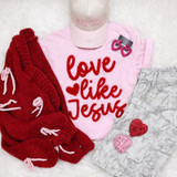 Love Like Jesus Red Fluffy Valentine's Day Patch, pink shirt with red text, red knitted cardigan, pink cap with 'SAVED' embroidered, pink and heart-shaped earrings, camouflage shorts, and decorative hearts for Valentine's Day.