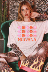 Product Grunge Band Tee DTF Heat Transfer, vintage style Nirvana T-shirt with smiley face design and band name, worn by a woman with leopard print sleeves, in a retro-themed setting.