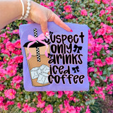 Suspect Only Drinks Iced Coffee DTF Heat Transfer, pink and black text with a graphic of a coffee cup with ice cubes and a pink bow, on a purple fabric background.