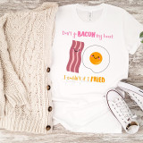 Don't Go Bacon My Heart I Couldn't If I Fried sublimation transfer T-shirt with cute bacon strip and sunny side up egg illustrations, playful text design, and vibrant colors.