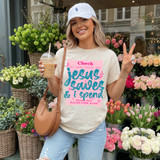 Jesus Saves & I Spend DTF Heat Transfer, women's casual T-shirt with colorful text design, outdoor flower shop background.