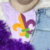 Mardi Gras Fleur De Lis Fluffy Patch – Chenille Iron-On Appliqué, colorful purple, green, yellow, and orange fleur-de-lis patch on a pastel purple T-shirt with denim jeans and a straw hat, with purple feather accents.