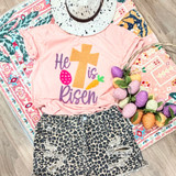 He Is Risen Chenille Fluffy Patch Transfer, pink T-shirt with colorful embroidered design featuring a cross, egg, and carrot, paired with animal print shorts, laid on a patterned cloth with decorative yarn eggs.