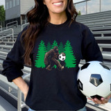 Big Creature Soccer DTF Heat Transfer, a graphic design of a Bigfoot holding a soccer ball with trees in a forest background, printed on a black sweatshirt.