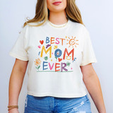 Best Mom Ever Crayon Art DTF Heat Transfer, colorful and playful hand-drawn style design on a white T-shirt featuring the phrase "Best Mom Ever" with flowers, hearts, a smiling sun, and various doodles.