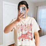 Pinchin' Stripes DTF Heat Transfer, a close-up photo of a woman wearing a T-shirt with a colorful lobster design and striped background, taking a mirror selfie in a bedroom.