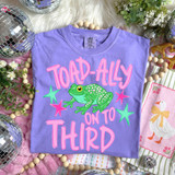 Toad-Ally On To Pink DTF Heat Transfer, vibrant purple t-shirt with a green frog, pink and green stars, and bold pink text for a fun, eye-catching design.